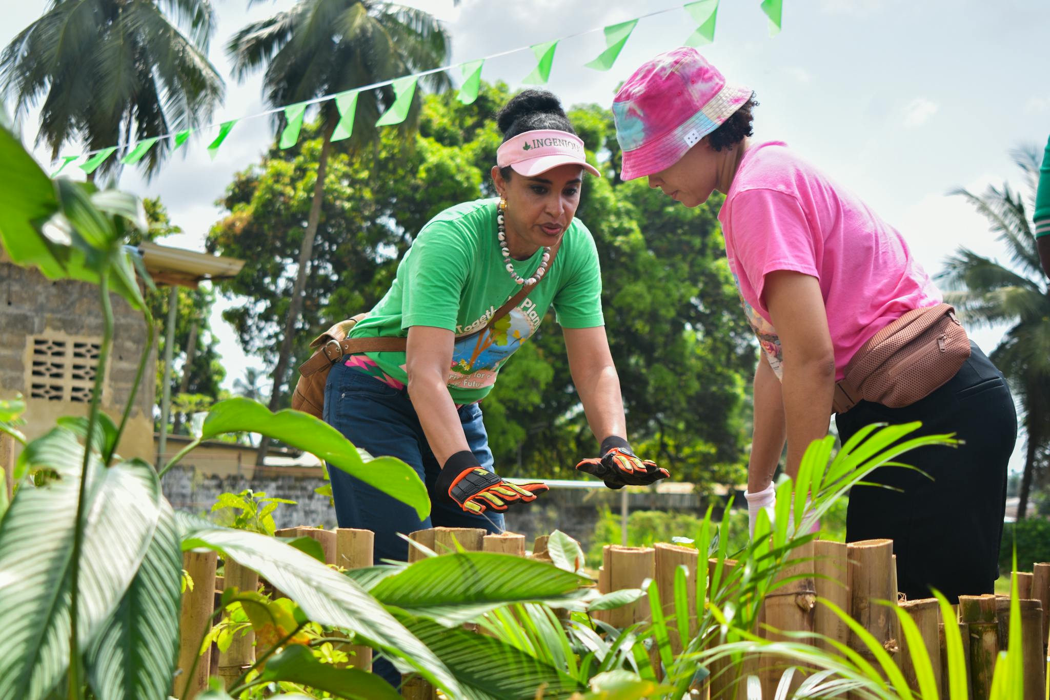 Two women engage in urban gardening in Monrovia, Liberia, promoting sustainable practices.